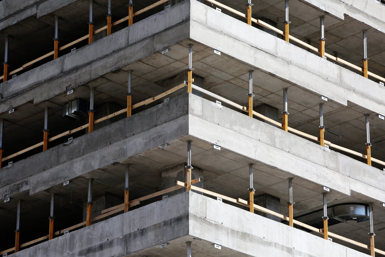 digital-01 Close-up of an unfinished multi-level concrete building with steel reinforcements.